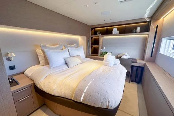 4ever VI Yacht Photos Pics Luxurious bedroom interior of 2022 Lagoon 67 yacht with modern design and cozy bedding.