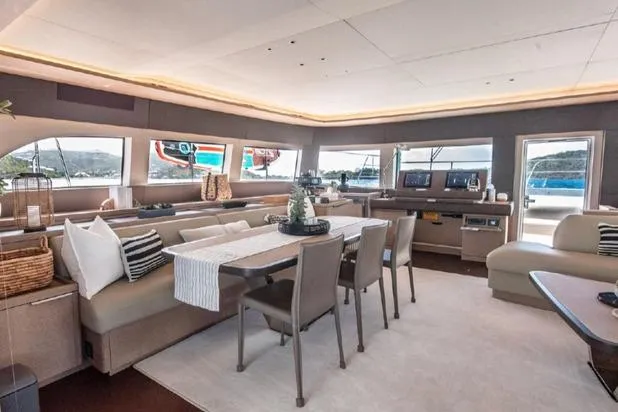 4ever VI Yacht Photos Pics Luxurious interior of 2022 Lagoon 67 yacht with elegant seating and dining area.