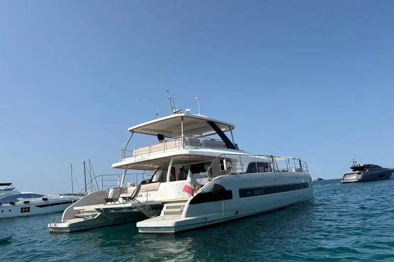 4ever VI Yacht Photos Pics 2022 Lagoon 67 yacht anchored in clear blue water, showcasing luxury and elegance.