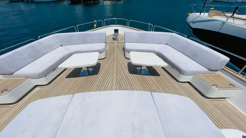  Yacht Photos Pics Luxurious 2024 Sirena 78 yacht deck with plush seating and tables, set against a serene ocean backdrop.