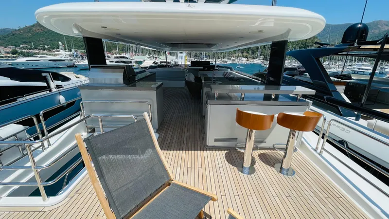 Yacht Photos Pics Luxurious 2024 Sirena 78 yacht deck with bar stools and scenic marina view.