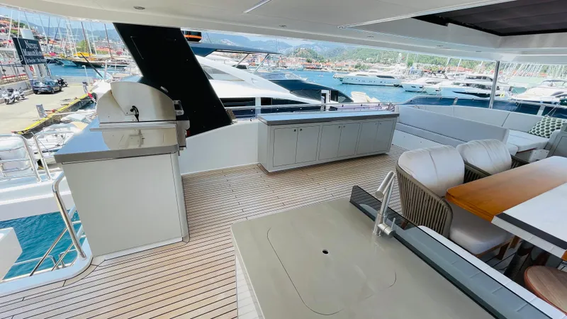  Yacht Photos Pics Luxurious 2024 Sirena 78 yacht deck with outdoor kitchen and dining area, docked at marina.
