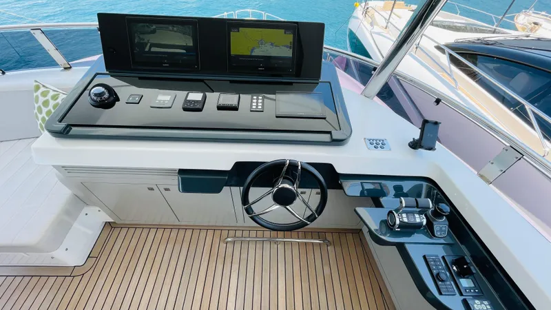  Yacht Photos Pics Helm station of 2024 Sirena 78 yacht with modern navigation equipment and wooden deck.