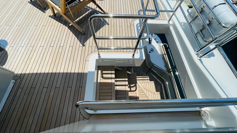  Yacht Photos Pics 2024 Sirena 78 yacht deck with wooden flooring and stainless steel railings.