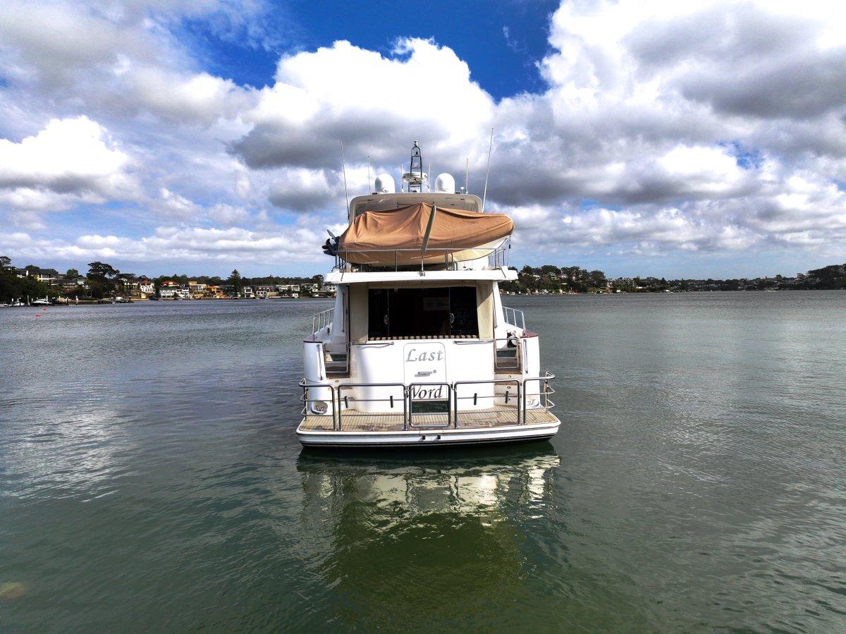 2011 Pama 65 Pilot House yacht on calm water under cloudy sky.