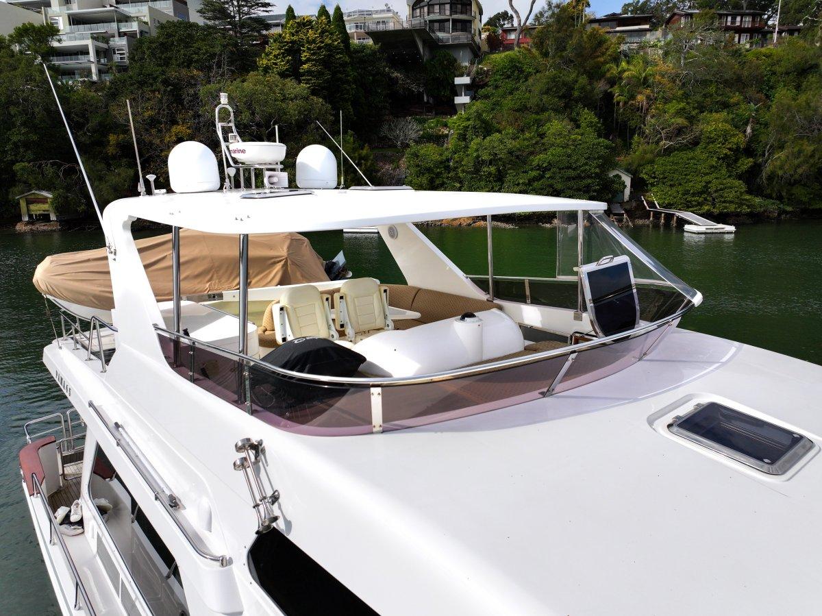 2011 Pama 65 Pilot House yacht on a serene waterway, surrounded by lush greenery.