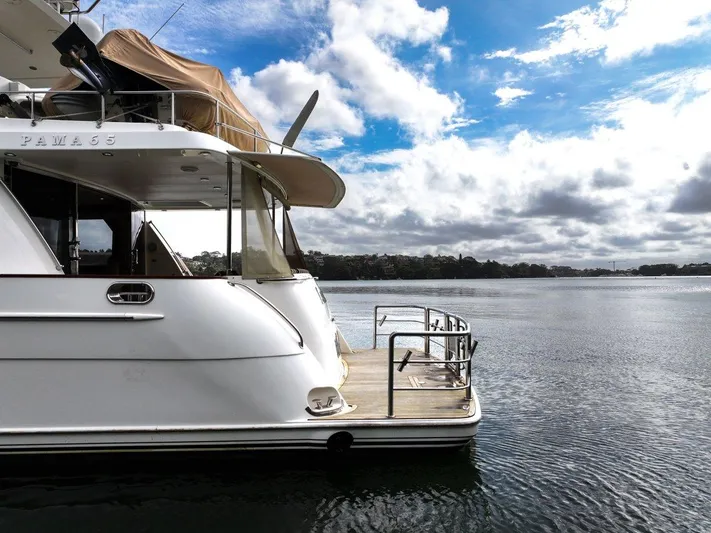 Pama 65 Pilot House Yacht Photos Pics Luxury 2011 Pama 65 Pilot House yacht docked on serene water under cloudy sky.
