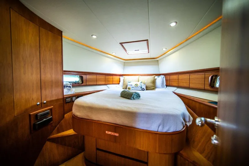Pama 65 Pilot House Yacht Photos Pics Luxurious bedroom interior of 2011 Pama 65 Pilot House yacht with wood paneling and cozy bedding.