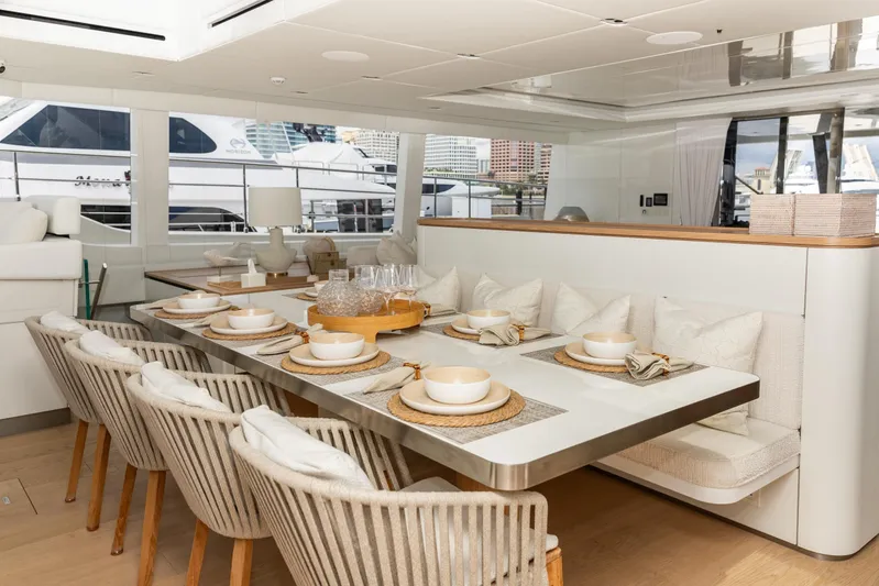 Fat Cat Yacht Photos Pics Luxurious dining area on 2024 Sunreef 80 Power Cat yacht, featuring elegant table settings.