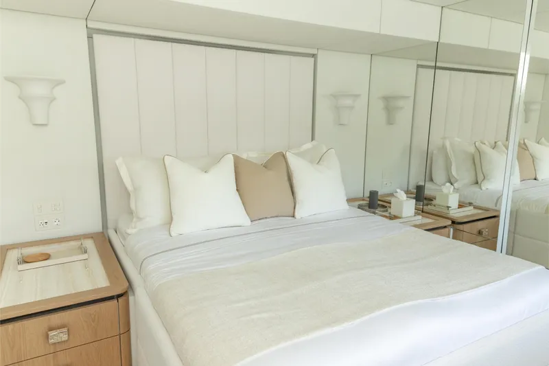 Fat Cat Yacht Photos Pics Luxurious bedroom interior on 2024 Sunreef 80 Power Cat yacht, featuring elegant bedding and mirrored walls.