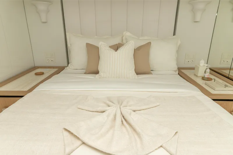 Fat Cat Yacht Photos Pics Luxurious bedroom interior on 2024 Sunreef 80 Power Cat yacht, featuring elegant bedding and decor.