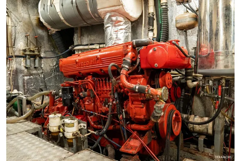 Deramore Yacht Photos Pics Red engine in a 1971 Dagless Ambassador boat, surrounded by mechanical components.