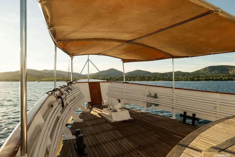 Deramore Yacht Photos Pics 1971 Dagless Ambassador yacht deck with canopy, overlooking serene waters and distant hills.