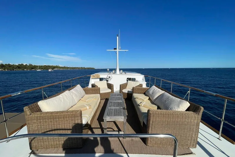 Deramore Yacht Photos Pics Luxury seating area on 1971 Dagless Ambassador yacht, overlooking serene ocean and clear blue sky.