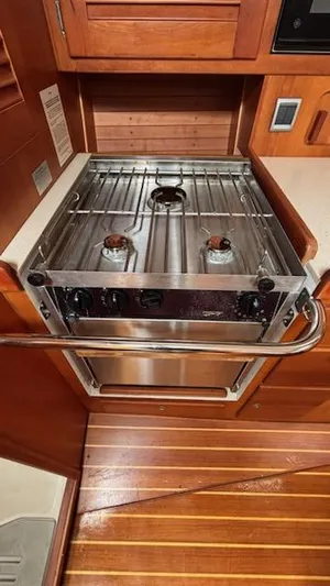 Wasabi Pea Yacht Photos Pics 2003 J Boats J/46 yacht kitchen with stainless steel stove and wooden cabinetry.