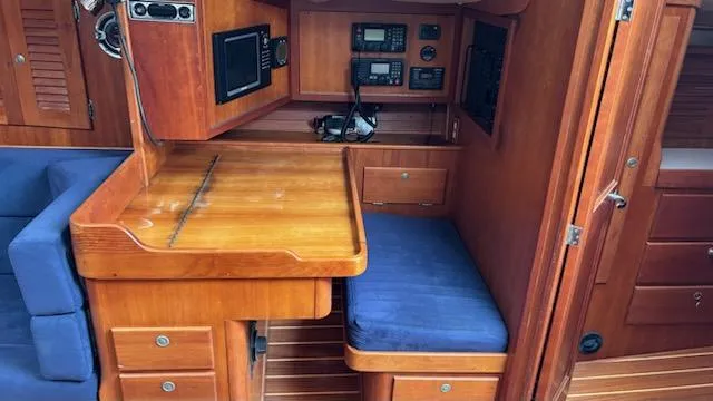 Wasabi Pea Yacht Photos Pics Interior of 2003 J Boats J/46 sailboat with navigation station and blue seating.