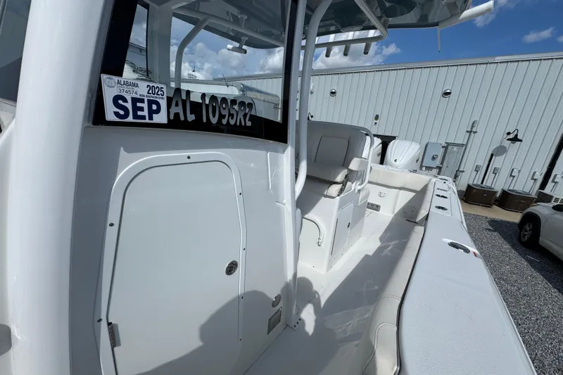  Yacht Photos Pics 2023 Sea Hunt Gamefish 30 Coffin Box boat, white interior, docked near a metal building.