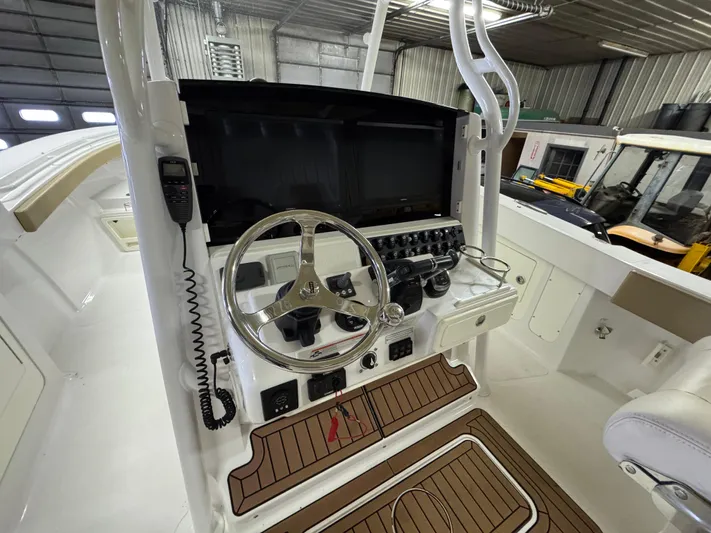  Yacht Photos Pics 2017 Southport 33 FE boat helm with steering wheel and control panel in a garage.