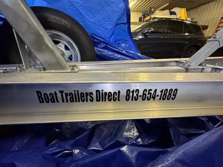  Yacht Photos Pics Boat trailer with contact info, Southport 33 FE, 2017 model, in a garage setting.