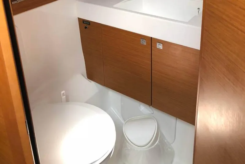 Albinez Yacht Photos Pics 2018 Jeanneau Sun Odyssey 479 yacht bathroom with wooden cabinets and modern fixtures.