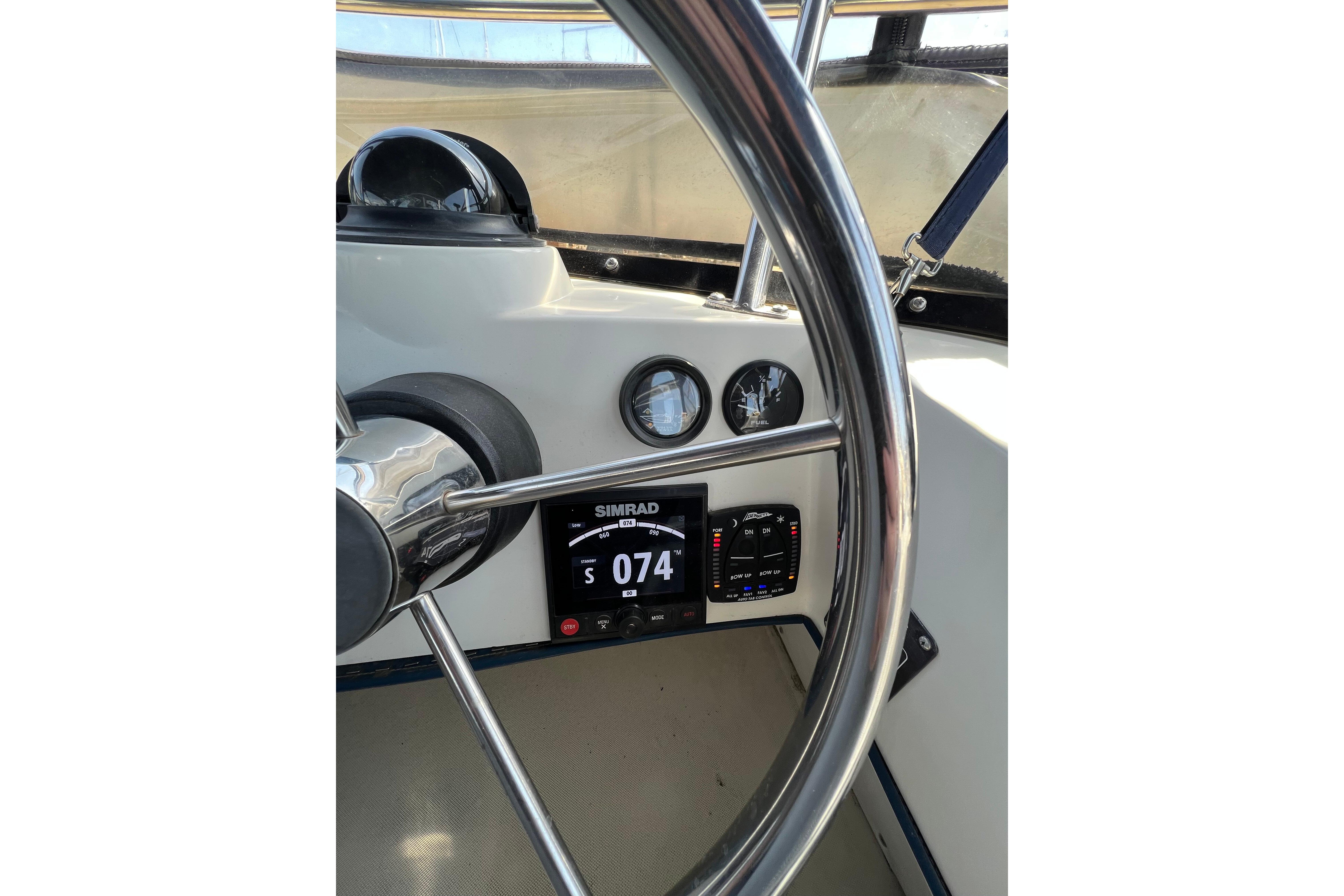 Steering wheel and dashboard of 2001 Skipjack 262 Flybridge boat with navigation instruments.