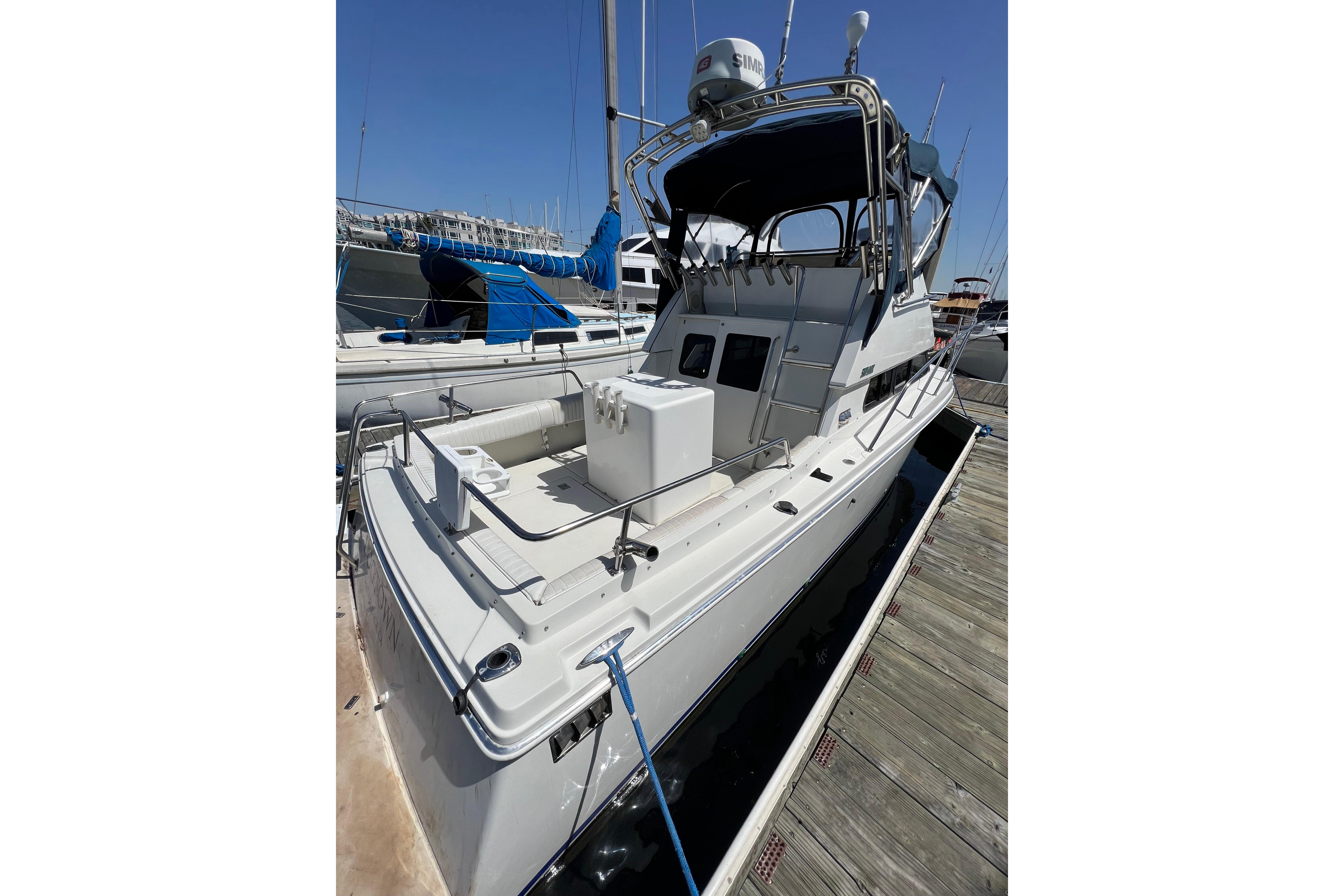 2001 Skipjack 262 Flybridge boat docked at marina, featuring spacious deck and flybridge.