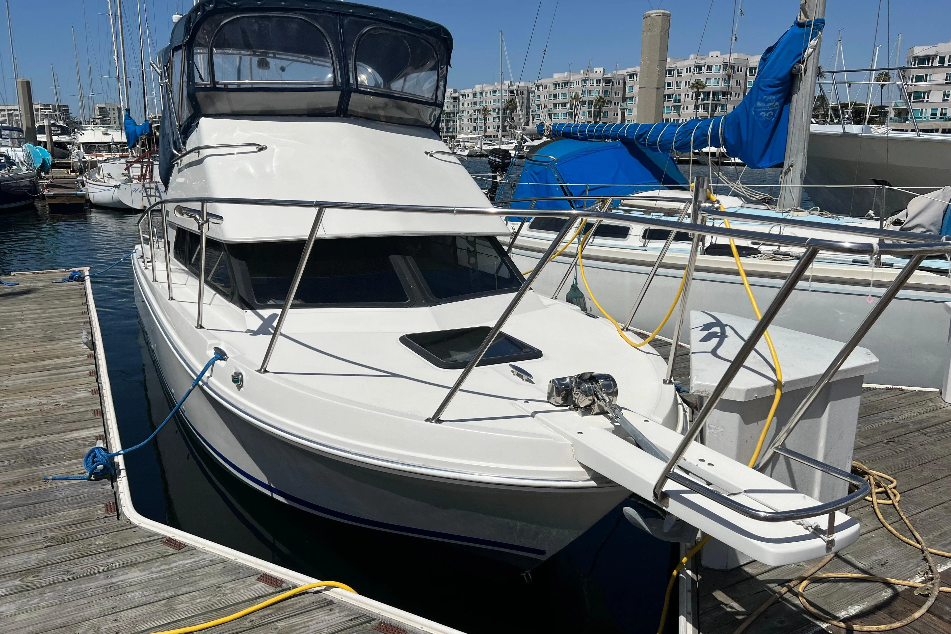 2001 Skipjack 262 Flybridge boat docked at marina, featuring sleek design and flybridge.