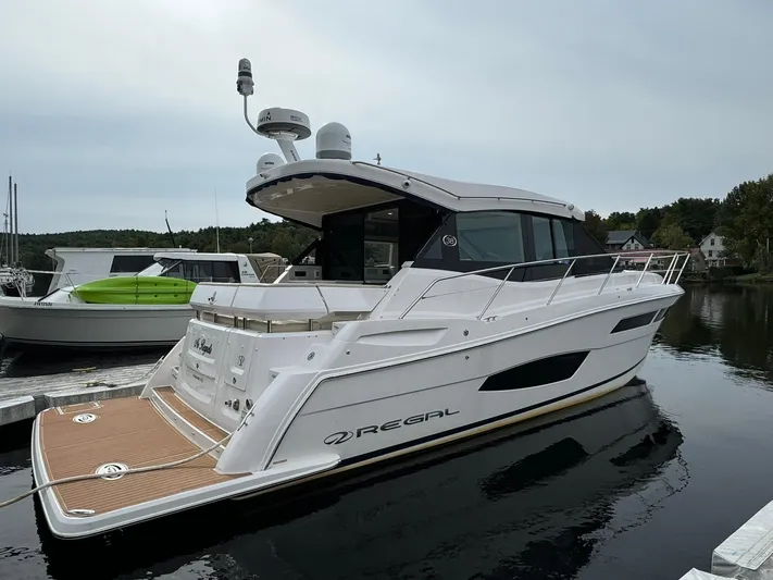 No Regrets Yacht Photos Pics 2020 Regal 38 Grande Coupe yacht docked on calm water, showcasing sleek design and modern features.