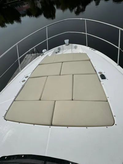 No Regrets Yacht Photos Pics 2020 Regal 38 Grande Coupe boat with cushioned sunbathing deck on calm water.