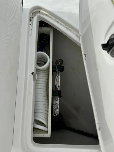 No Regrets Yacht Photos Pics Storage compartment on a 2020 Regal 38 Grande Coupe boat with coiled hose.