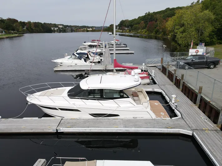 No Regrets Yacht Photos Pics 2020 Regal 38 Grande Coupe docked at a scenic marina with other boats.