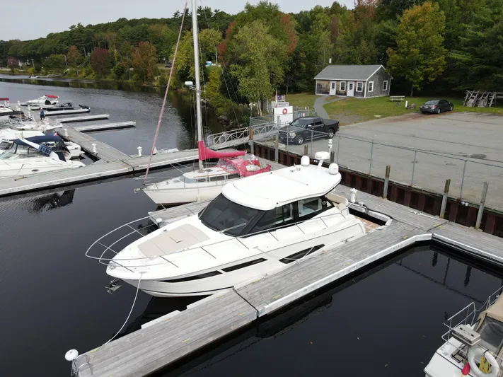 No Regrets Yacht Photos Pics 2020 Regal 38 Grande Coupe docked at a serene marina with lush greenery.