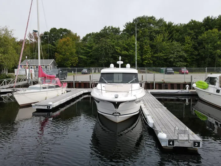 No Regrets Yacht Photos Pics 2020 Regal 38 Grande Coupe docked at marina with surrounding sailboats and trees.