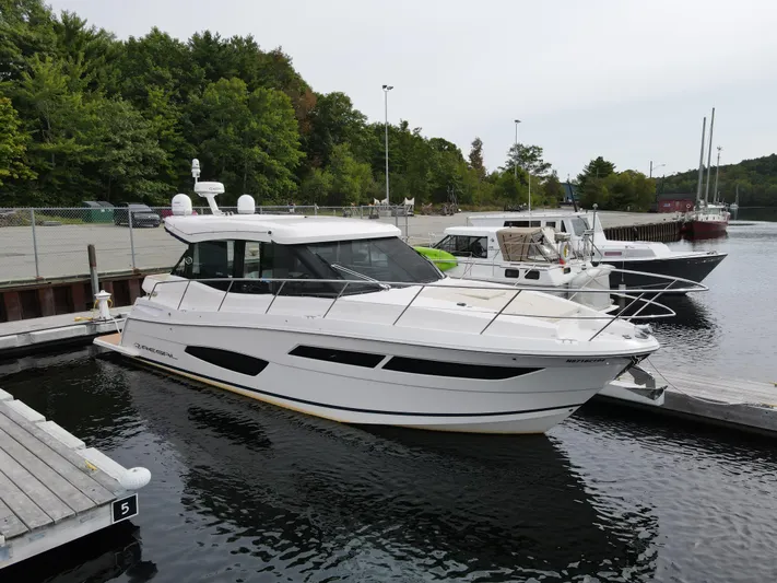 No Regrets Yacht Photos Pics 2020 Regal 38 Grande Coupe docked at a marina, surrounded by lush greenery.