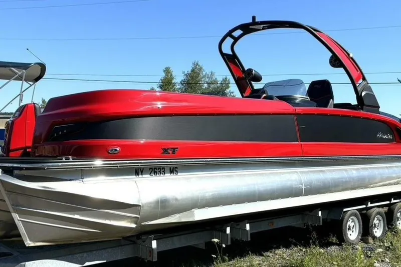  Yacht Photos Pics 2022 Manitou XT 27 SRW pontoon boat in vibrant red on a trailer.