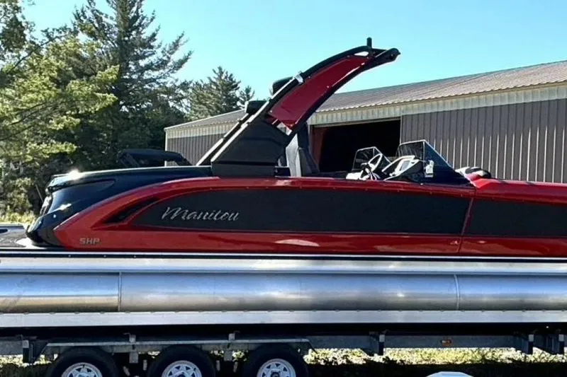  Yacht Photos Pics 2022 Manitou XT 27 SRW pontoon boat on trailer, red and black design, outdoors.
