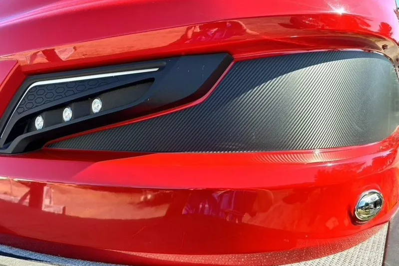  Yacht Photos Pics Close-up of 2022 Manitou XT 27 SRW's sleek red exterior and modern headlight design.