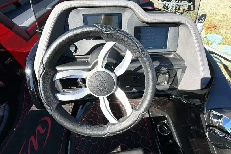  Yacht Photos Pics Steering wheel and dashboard of 2022 Manitou XT 27 SRW boat, featuring modern controls.