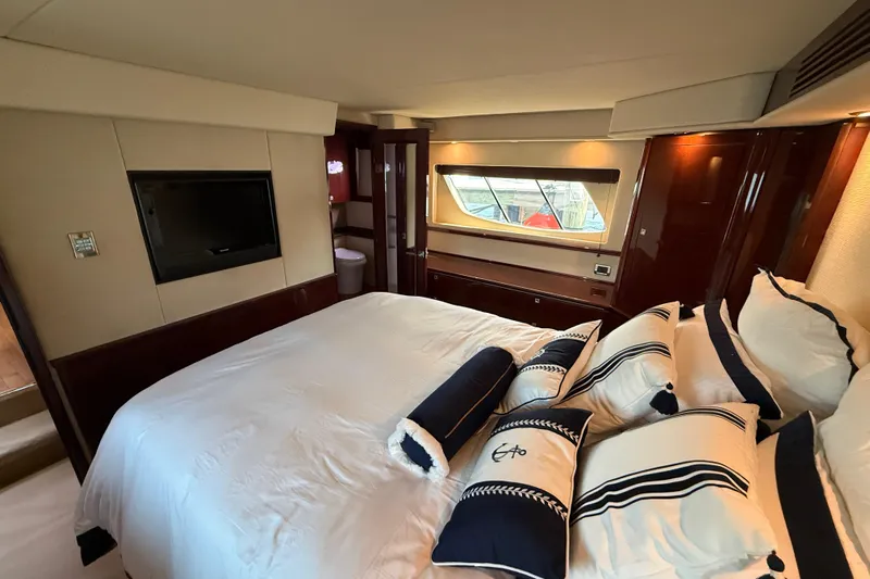 Positive Vibes Yacht Photos Pics Luxurious bedroom interior of 2008 Sea Ray 550 Sundancer yacht with elegant bedding and window view.