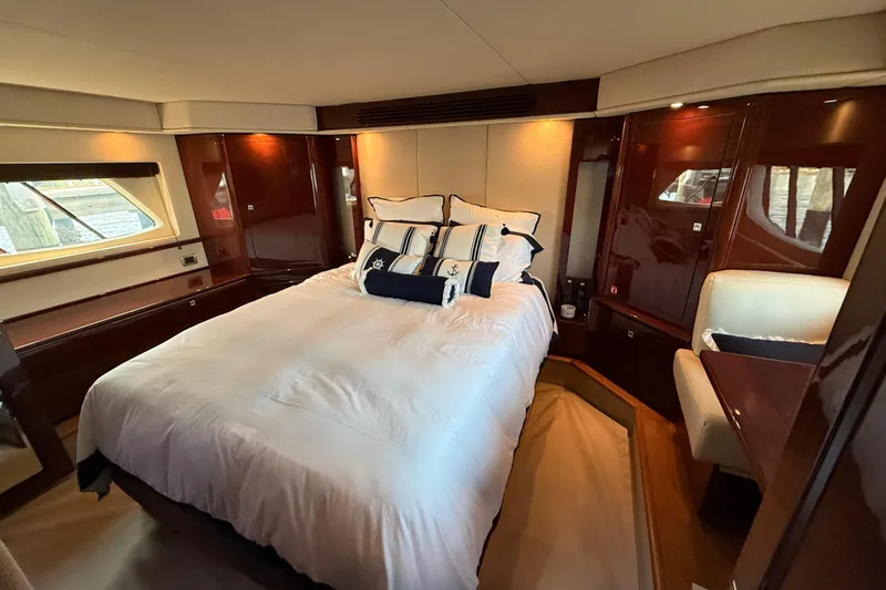 Positive Vibes Yacht Photos Pics Luxurious bedroom interior of 2008 Sea Ray 550 Sundancer yacht with elegant wood finishes.