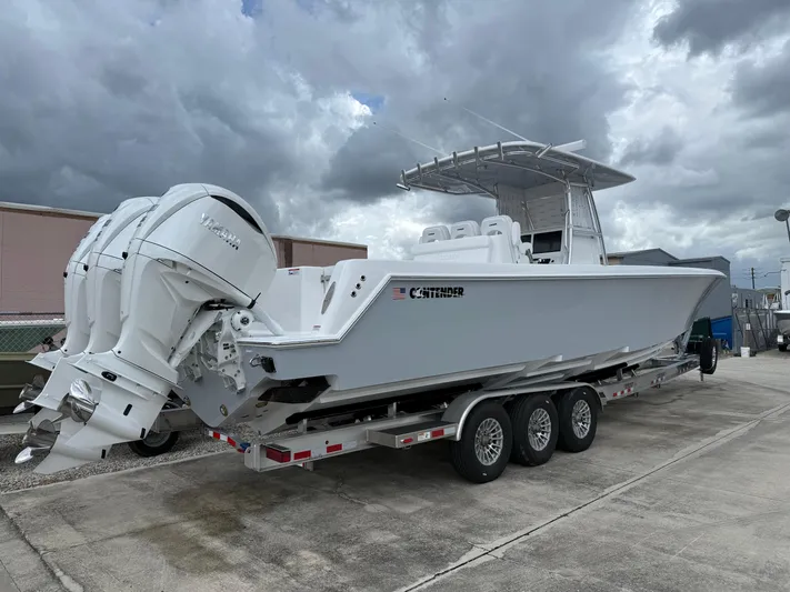  Yacht Photos Pics 2026 Contender 39 ST boat on trailer with triple outboard engines, under cloudy sky.
