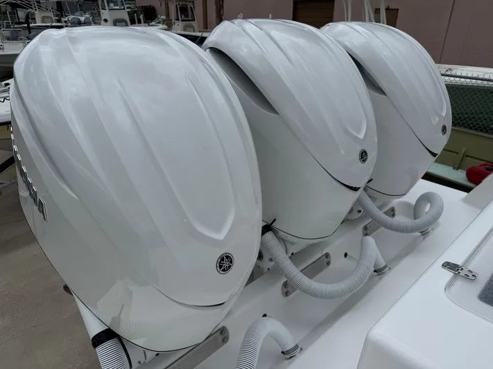  Yacht Photos Pics Triple outboard motors on a 2026 Contender 39 ST boat, showcasing sleek design and power.