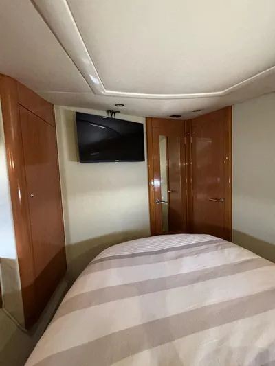  Yacht Photos Pics 2009 Sealine F42/5 yacht interior with bed, TV, and wooden cabinetry.