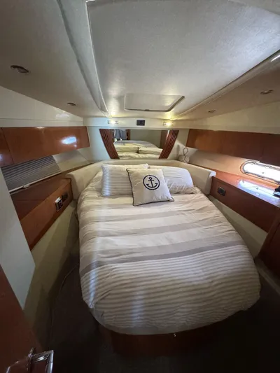  Yacht Photos Pics 2009 Sealine F42/5 yacht cabin with cozy bed, striped bedding, and nautical-themed pillow.