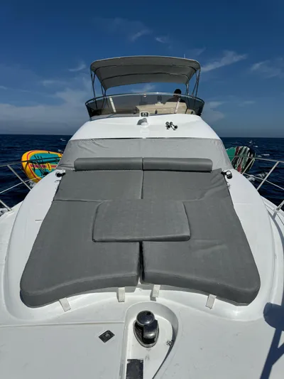  Yacht Photos Pics 2009 Sealine F42/5 yacht with sunbed on deck, cruising on open sea under clear sky.