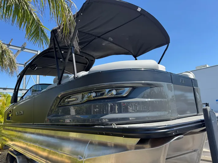  Yacht Photos Pics 2025 Avalon Excalibur 27' pontoon boat with canopy, sleek design under clear blue sky.