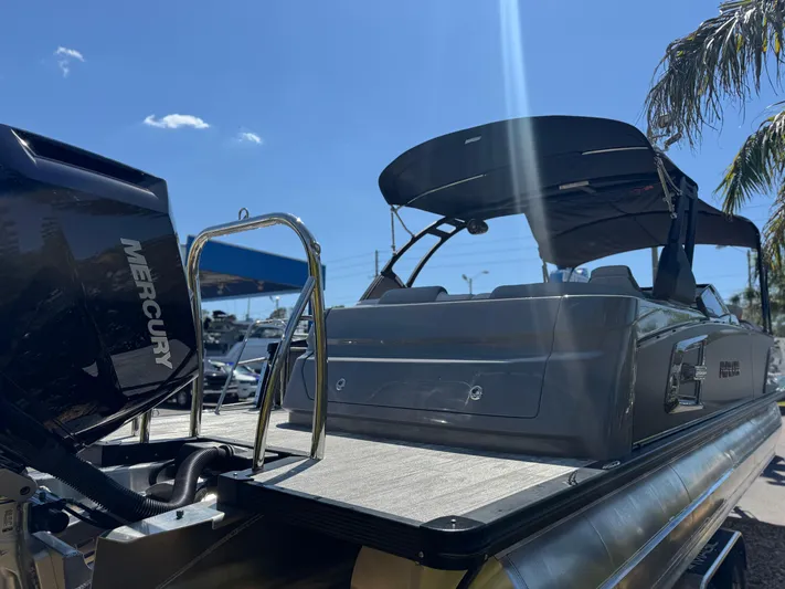  Yacht Photos Pics 2025 Avalon Excalibur 27' boat with Mercury engine, docked under clear blue sky.