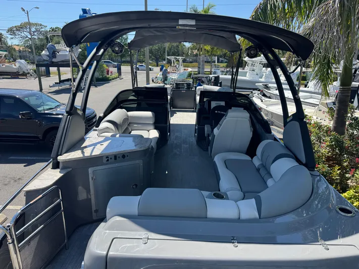  Yacht Photos Pics 2025 Avalon Excalibur 27' boat with luxurious seating and sleek design in a marina setting.