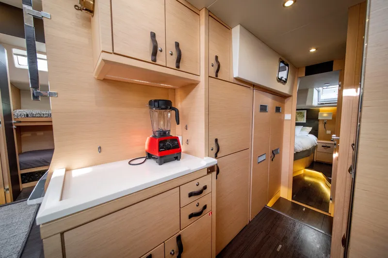 Serenity Yacht Photos Pics Luxurious interior of a 2016 Jeanneau 64 yacht featuring a modern kitchen and cozy bedroom.