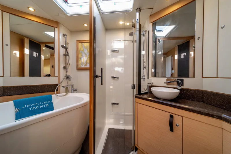 Serenity Yacht Photos Pics Luxurious bathroom on a 2016 Jeanneau 64 yacht with bathtub and modern fixtures.